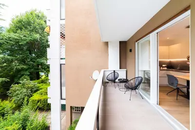 a balcony with chairs and a table on it at Meranosuites - Garden in Merano