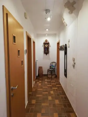 a hallway with a door and a clock on the wall at Haus Möltner - Apartment Aviam in Caldaro