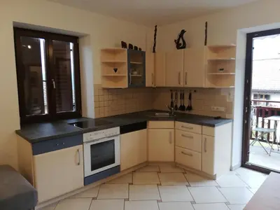 a small kitchen with white cabinets and a window at Haus Möltner - Apartment Aviam in Caldaro
