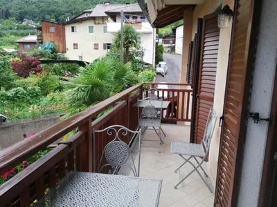 a balcony with two chairs and a table at Haus Möltner - Apartment Aviam in Caldaro
