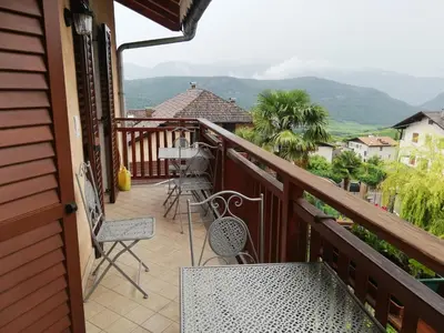 a balcony of a house with chairs and a table at Haus Möltner - Apartment Aviam in Caldaro