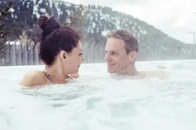 a man and a woman in a bathtub at Berghotel Jochgrimm - Your Dolomites Home in Varena