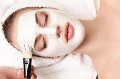 a woman with a moisturizing mask on her face with a brush at Berghotel Jochgrimm - Your Dolomites Home in Varena