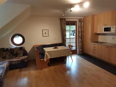a living room with a table and a kitchen at Residence Bad Bergfall in Valdaora
