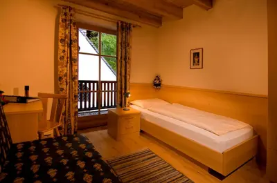a hotel room with a bed and a balcony at Residence Bad Bergfall in Valdaora