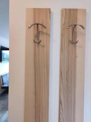 two wooden doors with metal handles on a wall at Eguia in Selva di Val Gardena