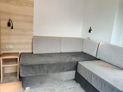 a bed in a small room with a table at Eguia in Selva di Val Gardena