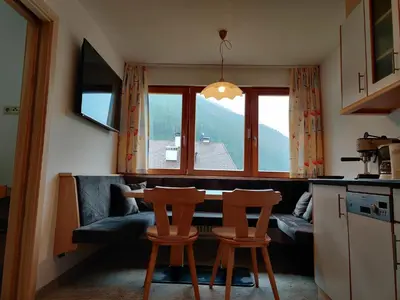 a kitchen with a table and two chairs and a couch at Eguia in Selva di Val Gardena