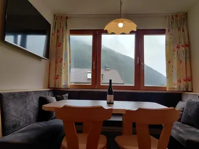 a wine bottle sitting on a table in a room with a window at Eguia in Selva di Val Gardena