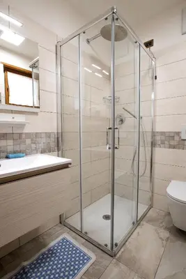 a shower with a glass door in a bathroom at Appartamenti Cèsa Crepa Neigra in Canazei