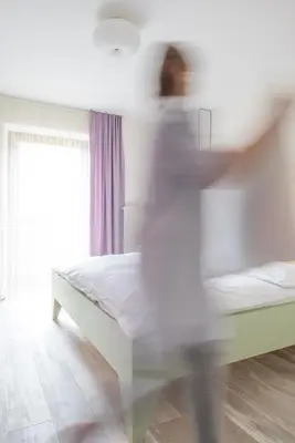 a person in a bedroom with a bed at Residence Vis à Vis in Rasùn di Sotto