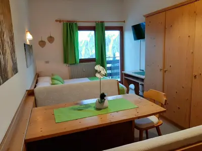 a living room with a couch and a table at Casa AQ28 sulle piste da sci in Falcade