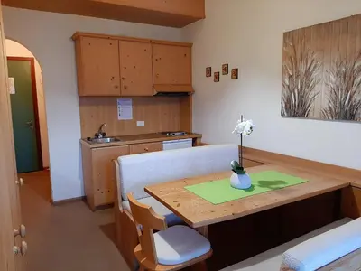 a kitchen with a wooden table with a vase on it at Casa AQ28 sulle piste da sci in Falcade