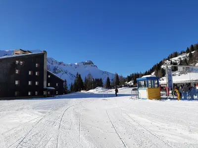 a snow covered slope with a building and a ski lift at Casa AQ28 sulle piste da sci in Falcade