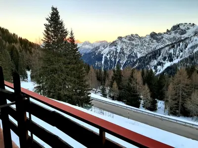 a view of a snow covered mountain range from a balcony at Casa AQ28 sulle piste da sci in Falcade