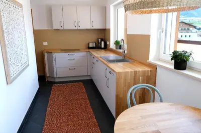 a kitchen with white cabinets and a table and a window at Apartment Plantitsch - Alpstay in Naturno