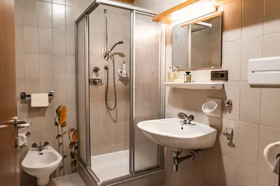 a bathroom with a shower and a sink and a toilet at Residence Greymold in Rifiano