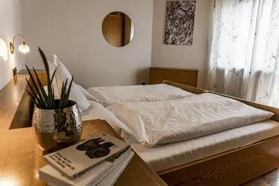 a room with a bed and a table with a book at Residence Greymold in Rifiano