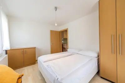 a small bedroom with a bed and a closet at The Muse Apartments in Selva di Val Gardena