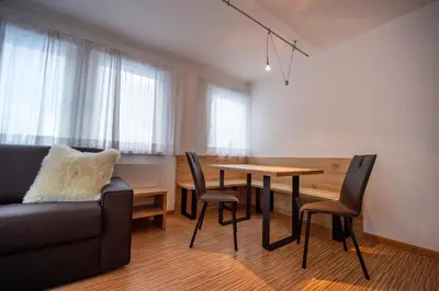 a living room with a couch and a table and chairs at The Muse Apartments in Selva di Val Gardena