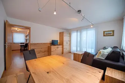 a living room with a wooden table and a couch at The Muse Apartments in Selva di Val Gardena