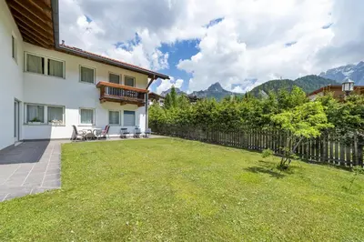 a backyard of a house with a fence at The Muse Apartments in Selva di Val Gardena