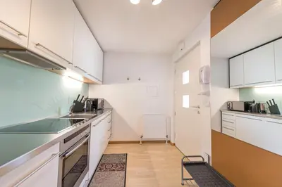 a kitchen with white cabinets and a counter top at The Muse Apartments in Selva di Val Gardena