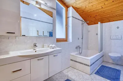 a bathroom with a sink and a tub and a toilet at Köstenholzerhof in Lana