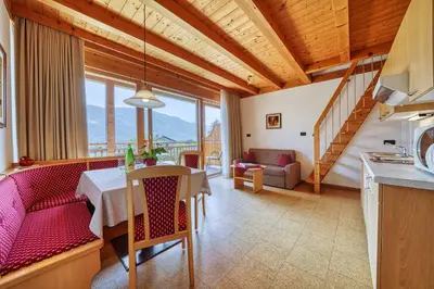 a kitchen and living room with a table and chairs at Köstenholzerhof in Lana