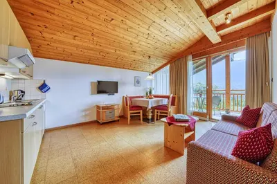 a kitchen and living room with a couch and a table at Köstenholzerhof in Lana
