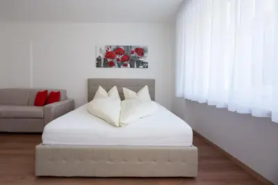a bed with white sheets and pillows in a room at Fior Apartments Pienzenau in Merano