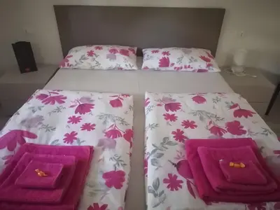 a bedroom with a bed with purple and pink flowers at Manuel's Home 1 FREE parking Wi-Fi AC in Bolzano