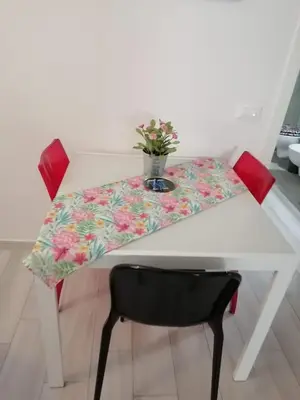 a table with a table cloth with a vase of flowers on it at Manuel's Home 1 FREE parking Wi-Fi AC in Bolzano