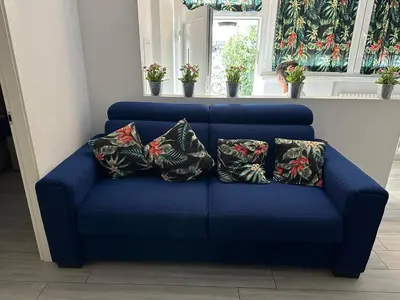 a blue couch with four pillows on it at Manuel's Home 1 FREE parking Wi-Fi AC in Bolzano