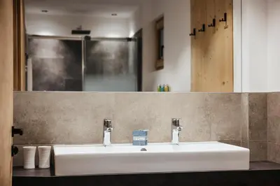 a bathroom with a white sink and a mirror at Chalet Dolecir in La Valle