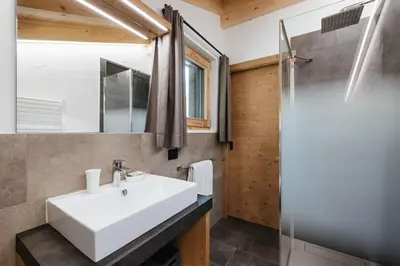 a bathroom with a white sink and a shower at Chalet Dolecir in La Valle