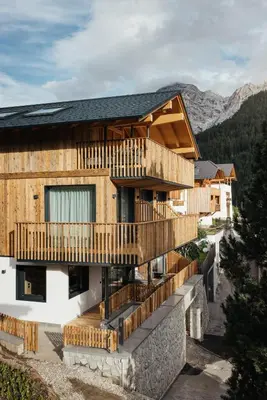 a house with wooden balconies on a mountain at Chalet Dolecir in La Valle