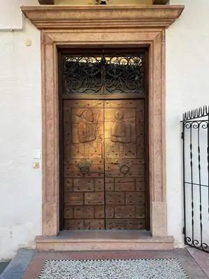 a large wooden door with statues on it at Design Apartment in the heart of Bolzano in Bolzano