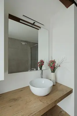 a bathroom with a white bowl sink and a mirror at Design Apartment in the heart of Bolzano in Bolzano