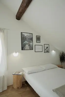 a bedroom with a white bed and pictures on the wall at Design Apartment in the heart of Bolzano in Bolzano