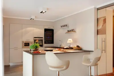 a kitchen with two white chairs and a counter at Crioli Dolomiti Lodge in Villabassa