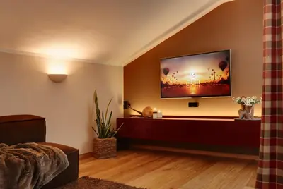 a living room with a flat screen tv on a wall at Crioli Dolomiti Lodge in Villabassa