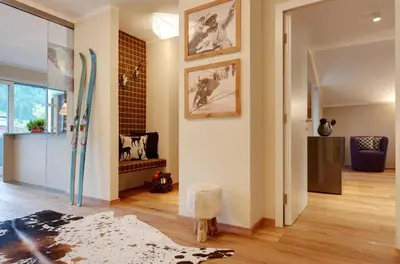 a living room with a hallway with a surfboard on the wall at Crioli Dolomiti Lodge in Villabassa