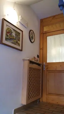 a room with a door and a clock on the wall at Ciasa Rosada in San Vigilio Di Marebbe