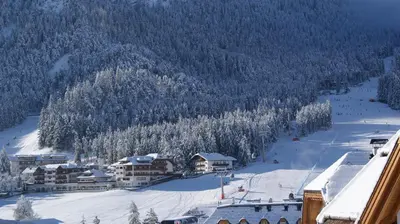 a ski resort with snow covered trees and buildings at Ciasa Rosada in San Vigilio Di Marebbe
