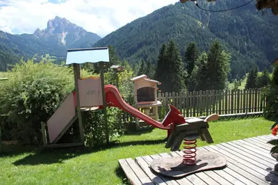 a childrens playground with a slide and a chair at Residence Bergheim in Braies