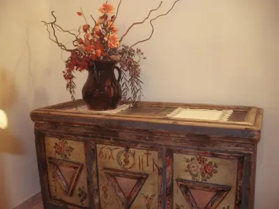 a vase with flowers sitting on top of a dresser at Appartamenti Cesa Maria Mountain Hospitality in Canazei