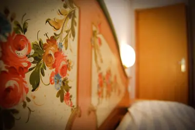 a bedroom with a wall with flowers painted on it at Appartamenti Cesa Maria Mountain Hospitality in Canazei
