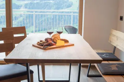 a table with a plate of food and two glasses of wine at Jaufnerhof in Mareta