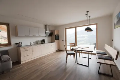 a kitchen and dining room with a table and chairs at Jaufnerhof in Mareta